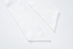 Detailed close-up of white fabric ribbon tie showing high-quality stitching and texture
