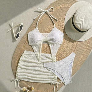 Flachliegendes weißes dreiteiliges Bikini-Set mit Wellentextur und Kordelzug-Pareo-Rock