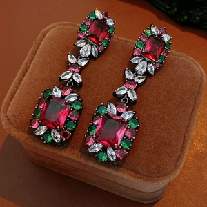 Macro view of vintage style earrings with large red rectangular zircon and multicolor gems