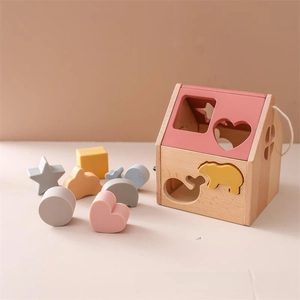 Detail of wooden shape sorting house toy with colorful animal blocks and smooth edges