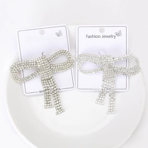 Detailed view of silver bow brooches adorned with sparkling rhinestones on display cards