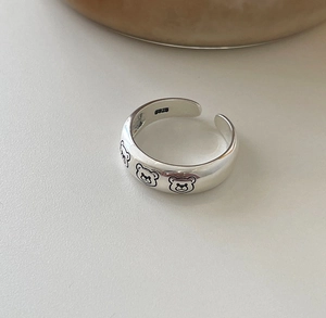 Macro detail of S925 sterling silver open ring featuring cute bear pattern engraving