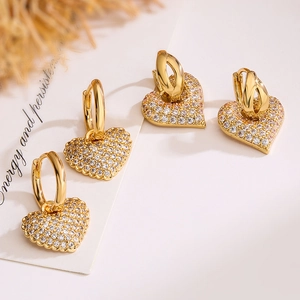 Elegant gold heart earrings with sparkling zircon crystals in a minimalist style