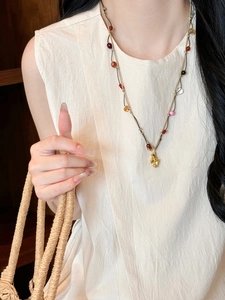Detailed shot of handmade woven necklace with colorful beads and golden pony pendant
