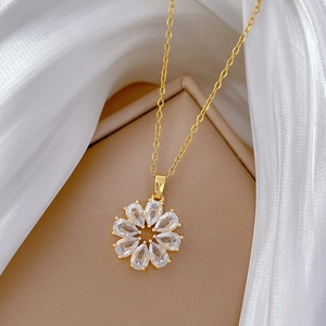 Gros plan d'un collier fleur doré avec pétales en zircon transparent sur soie