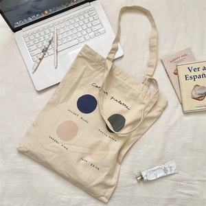 Detailed view of cream canvas tote bag with color palette print on fabric