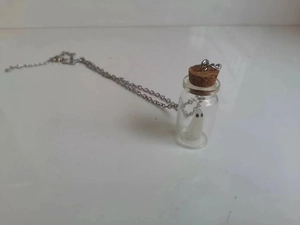 Detailed view of the adopt a ghost miniature glass bottle necklace with cork and silver chain