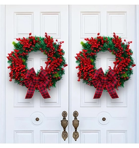 Symmetric display of Christmas wreaths with red berries and black-red plaid bows on white doors