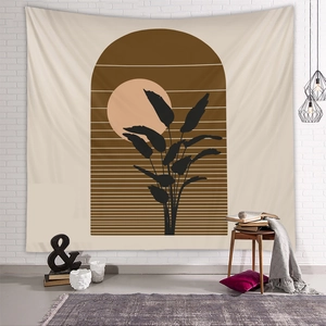Detail view of Bohemian wall tapestry with abstract sun and tropical leaves on brick wall