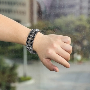 Close-up of men's punk skull bracelet in silver and black stainless steel finish