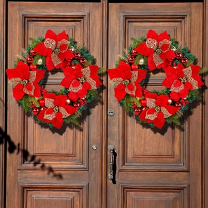 Set of two large red Christmas wreaths with gold ornaments on a dark wooden door