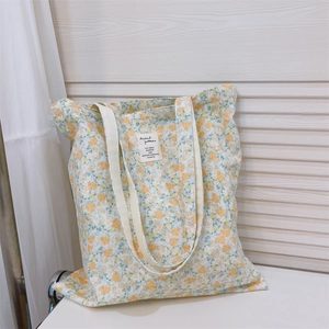 Detail of floral canvas tote bag with cream velvet texture and animal pattern tag