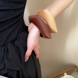Détail de la texture naturelle du bois sur des bracelets larges et minimalistes
