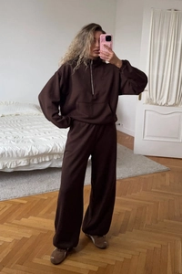 Detailed view of dark brown half-zip sweatshirt and matching wide-leg knit trousers