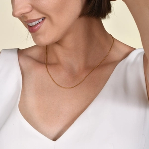 Minimalist 1mm gold stainless steel clavicle chain necklace worn by a fashion model
