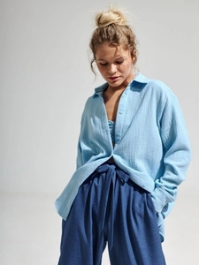 Close-up of light blue cotton crepe fabric texture on a long-sleeve casual shirt