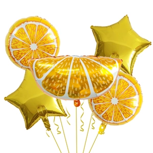 Detail of orange fruit slice and gold star foil balloons for summer party decoration