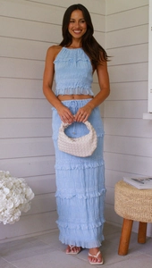 Detail view of light blue smocked two-piece set featuring halter crop top and tiered maxi skirt