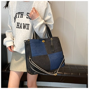 Détail du sac à main en denim bicolore avec fermoir doré et bandoulière ajustable