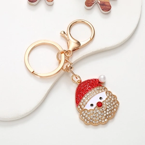 Close-up of Santa Claus keychain with red rhinestones and a white pearl on a tray