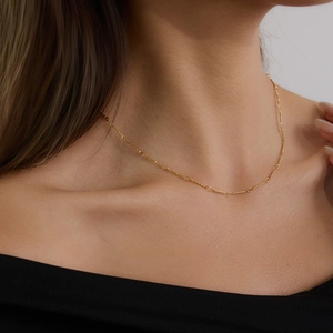 Classic 18K gold plated stainless steel thin chain necklace worn on a woman's collarbone