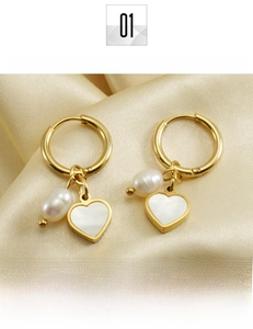 Détail de boucles d'oreilles cœur en acier plaqué or 18K avec perles sur soie