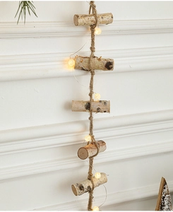 Detail of wooden branch wall decor with warm LED lights and rustic jute rope hanging