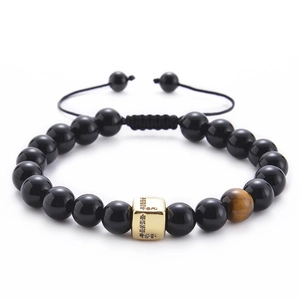 Close-up of black onyx and tiger eye bead bracelet with a gold zircon L-letter charm