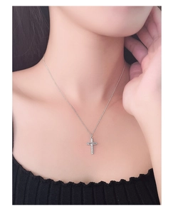 Close-up of S925 silver necklace with irregular cross pendant worn on woman's neck