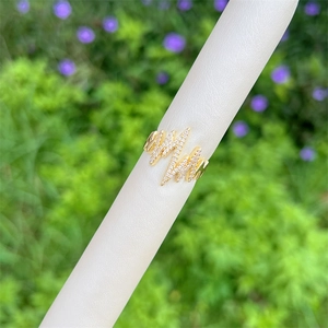 Macro detail of 18K gold plated heart rate wave ring with paved white zircons