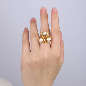 Gros plan détaillé d'une bague florale en or 18 carats avec perles sur une main féminine