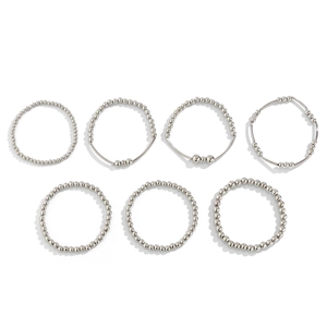 Detail view of 7-piece silver metal beaded ring set showing various bead sizes and textures