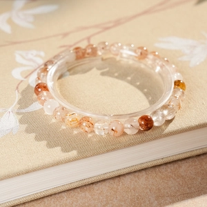 Macro detail of natural red rutilated quartz beaded bracelet on a notebook background