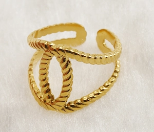 Macro shot of gold-plated open adjustable ring with twisted rope texture and double C design