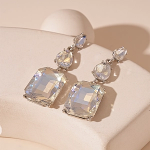 Détail macro de boucles d'oreilles avec cristaux rectangulaires et en goutte sur socle