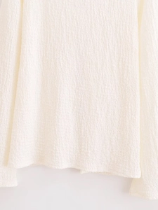 Detail shot showing the pleated texture and fabric quality of the white resort set top