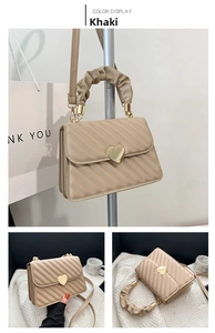 Detail of khaki quilted shoulder bag featuring gold heart buckle and ruched handle