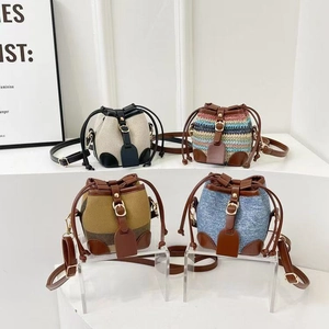 Detail of four mini drawstring bucket bags in denim, plaid, and woven texture finishes