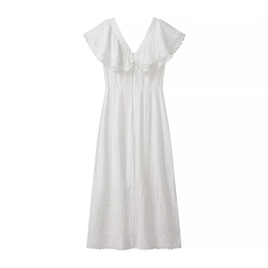 Dettaglio di un abito lungo bianco con scollo a V e ricami traforati in pizzo eleganti