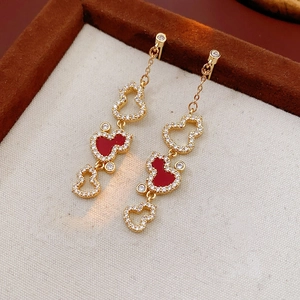 Macro shot of gold-plated gourd tassel earrings with red enamel and pavé zircons