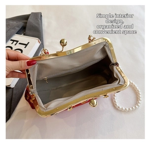 Détail du sac à main rouge brodé avec poignée en perles et poche intérieure zippée