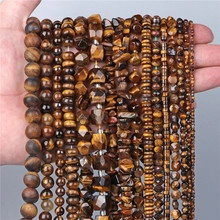 Detailed view of hand-held natural tiger eye stone beads in various shapes for jewelry DIY