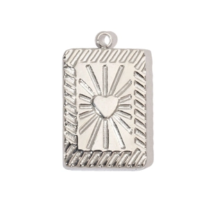 Detailed macro view of a silver rectangle heart pendant with engraved sunburst patterns