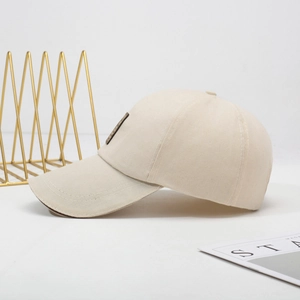 Minimalist beige cotton baseball cap with side patch shown from a 45-degree angle