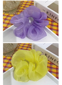 Gros plan de chouchous volumineux en organza violet et jaune sur fond à carreaux