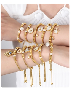 Detail of 18K gold-plated beaded bracelets featuring Hamsa Hand and Evil Eye charms