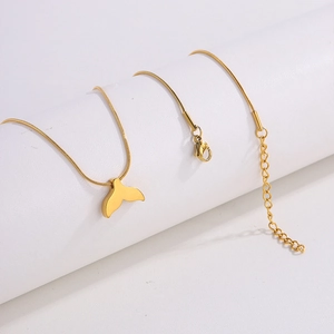 Close-up of golden whale tail pendant on a sleek snake chain necklace for women