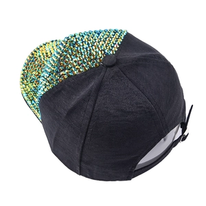 Detailed view of rhinestone baseball cap featuring a shiny sequined brim and adjustable buckle