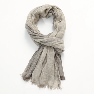 Detail of color-block scarf featuring pleated linen texture and frayed fringe edges