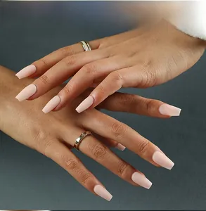 Detail of nude pink matte coffin fake nails showing texture and fit on hands